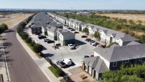 La Joya Apartments External Aerial Photo - Aerial view of La Joya Apartments showcasing a residential neighborhood with cars parked in driveways