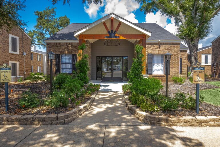 Exterior view of Edgewater Pointe Apartments in Biloxi, MS, showcasing the entrance and nearby park area