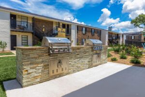 Outdoor grilling area at Edgewater Pointe Apartments in Biloxi, MS, featuring a BBQ grill amidst a park set