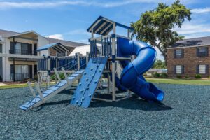 Outdoor playground at Edgewater Pointe Apartments in Biloxi, MS, showcasing various play structures for kids
