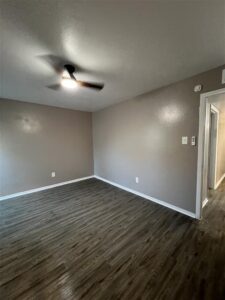 Modern living room in a 3-bedroom apartment at Trailwood Village in Kingwood, TX, featuring wood-style flooring and updated lighting.
