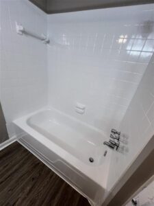 Modern bathroom in the 3 bedroom Abberly floor plan at Trailwood Village Apartments in Kingwood featuring white subway tile surround and wood-style flooring.