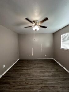 Bedroom in a 3-bedroom Abberly apartment at Trailwood Village featuring a built-in closet organization system and wood-style flooring.